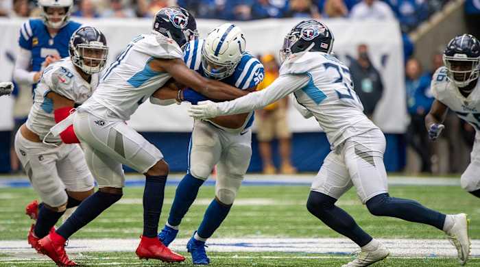 Oct 31, 2021; Indianapolis, Indiana, USA; Indianapolis Colts running back Jonathan Taylor (28) is tackled by multiple Tennessee Titans during the second half at Lucas Oil Stadium. Titans won 34-31.